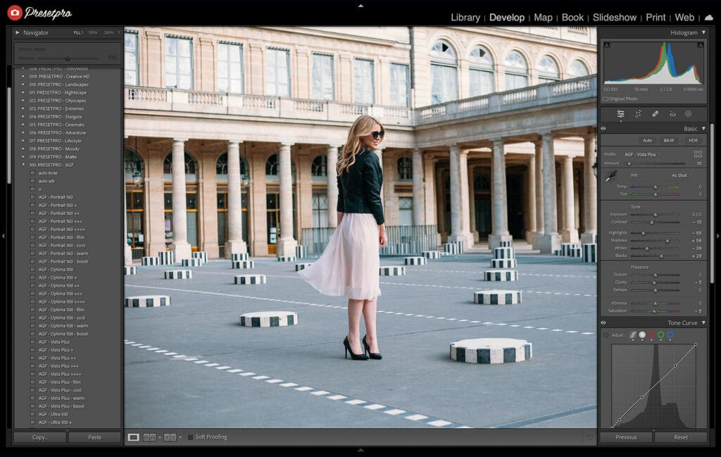 A photo of a woman in a light pink dress and black jacket standing in an urban courtyard with striped columns, edited using the Agfa Vista Plus 200 Film Emulation Lightroom Preset to achieve vibrant colors, fine grain, and moderate contrast for a classic analog film look. The Lightroom interface shows the preset applied with adjustments to tone and color settings.