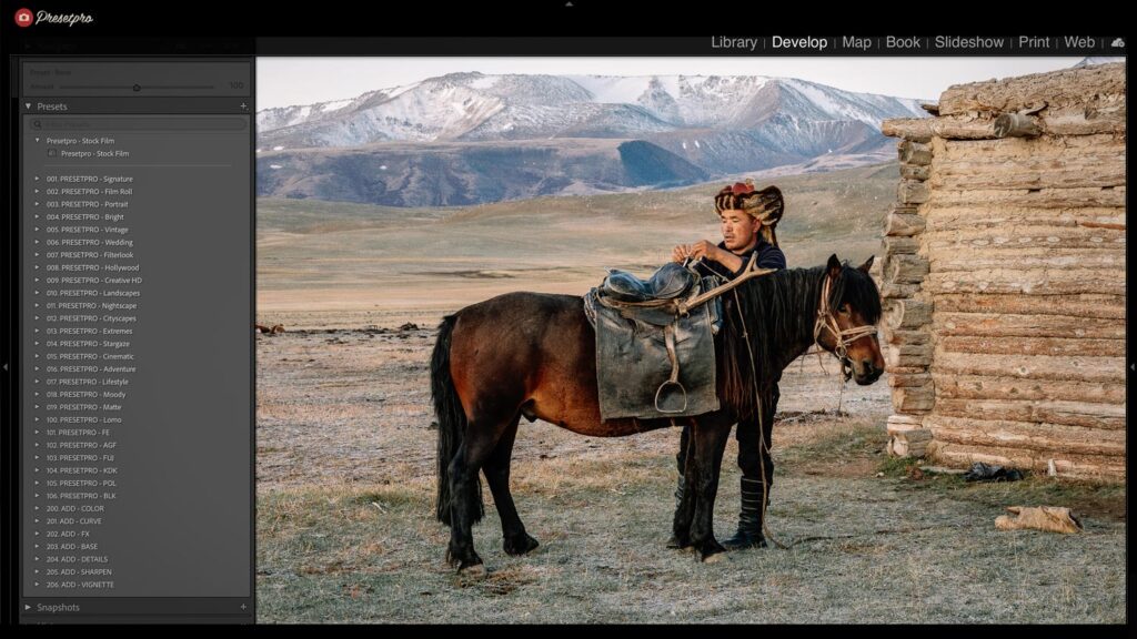 Photo of a man on horseback with a backpack, set in a vast, open, mountainous landscape background.