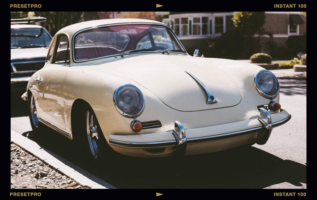 A classic cream-coloured sports car parked on a sunlit street, framed in a retro film border. The photo demonstrates the Instant 100 Lightroom preset, inspired by Fuji FP-100C, featuring faded shadows and rich analogue warmth.