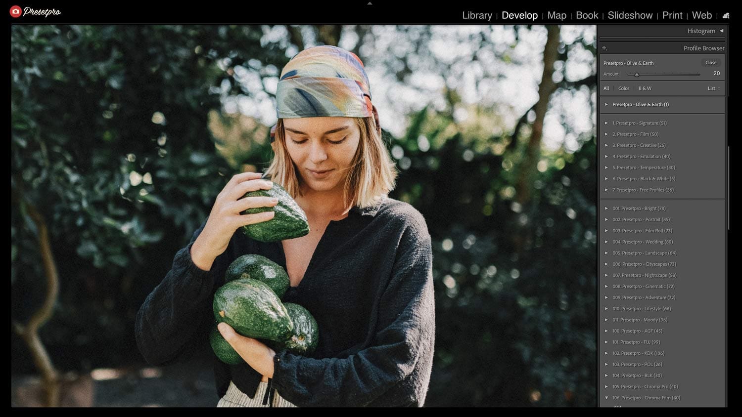 Woman holding fresh watermelons outdoors in a lush garden setting.